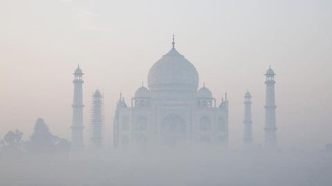 The Taj Mahal shrouded in dense smog—an iconic symbol veiled by the deadly intersection of air pollution and rising temperatures in India.
