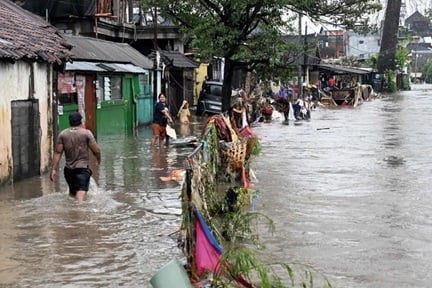 Residents wading through flood waters after heavy rain in Bali on Sept 10.  PHOTO: AFP