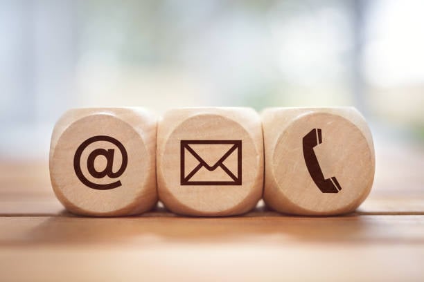 Three dice close together showing @, email, and telephone contact icons