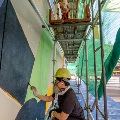8EyedSpud painting the 6.4m tall Becoming mural on scaffolding