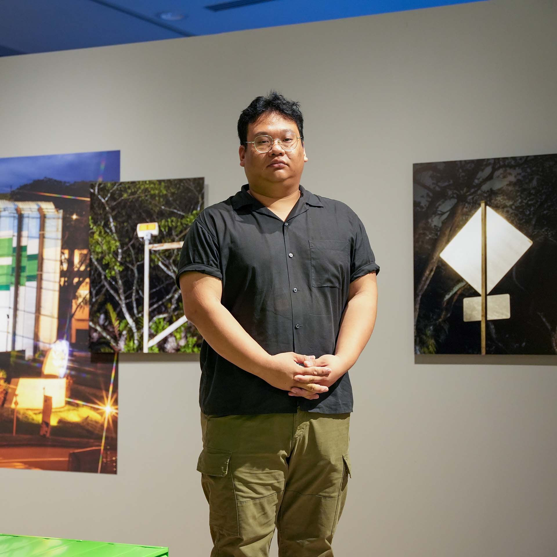 Marvin Tang standing in front of his artwork Further Reading