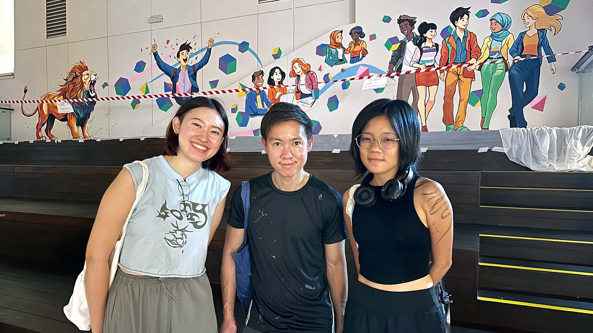 OneNTU Mural - artist Jaxton Su and his team Aly and Hui Ru in front of the mural in progress