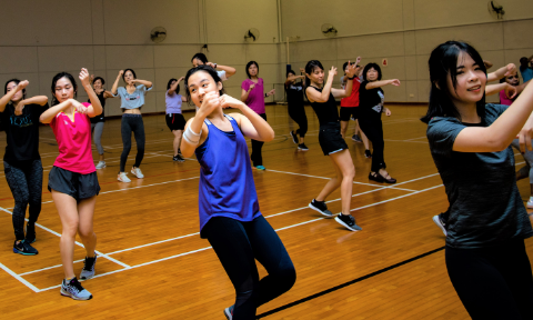 A group of NTU staff and students having fun at a mass kick-boxing fitness class