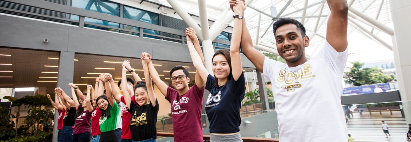 A group of students with their arms in the air