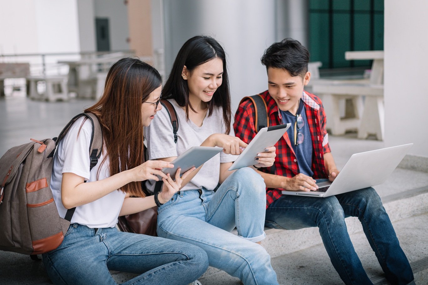 3 students looking at tablets