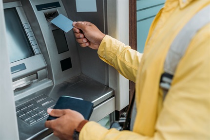 Man putting credit card in atm machine
