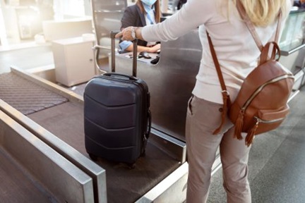 woman with backpack weighing luggage at airport check in