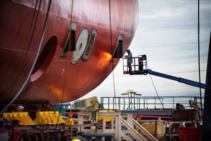 Worker Repairing Container Ship At Industry