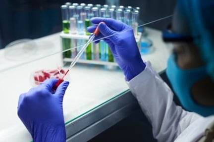 scientist sampling blood in test tubes while working on research in laboratory