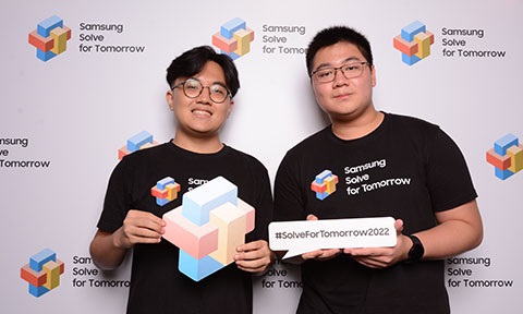 Photo of two undergraduates taking part in a competition, posing in front of a backdrop.