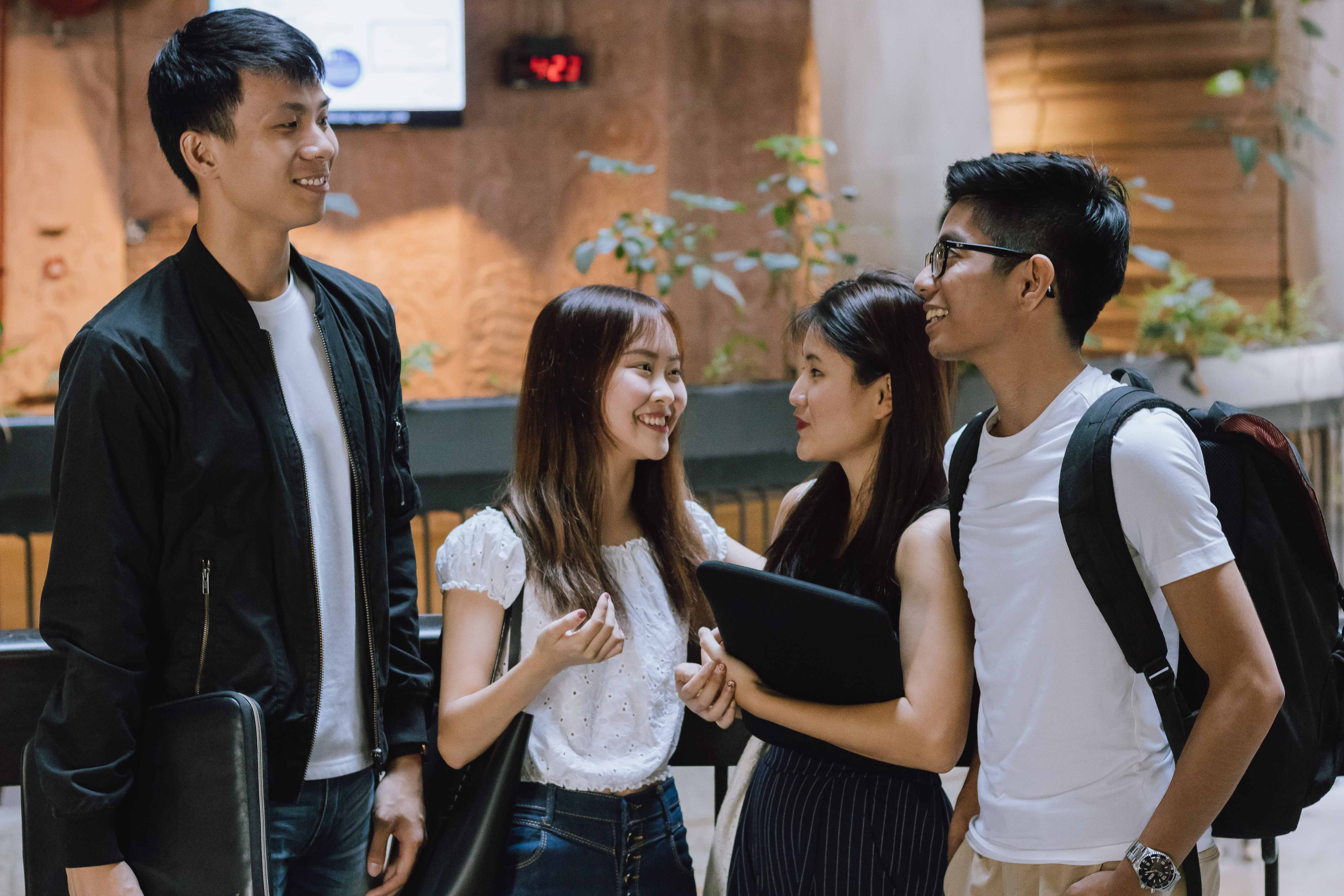 four students chatting outside their classroom