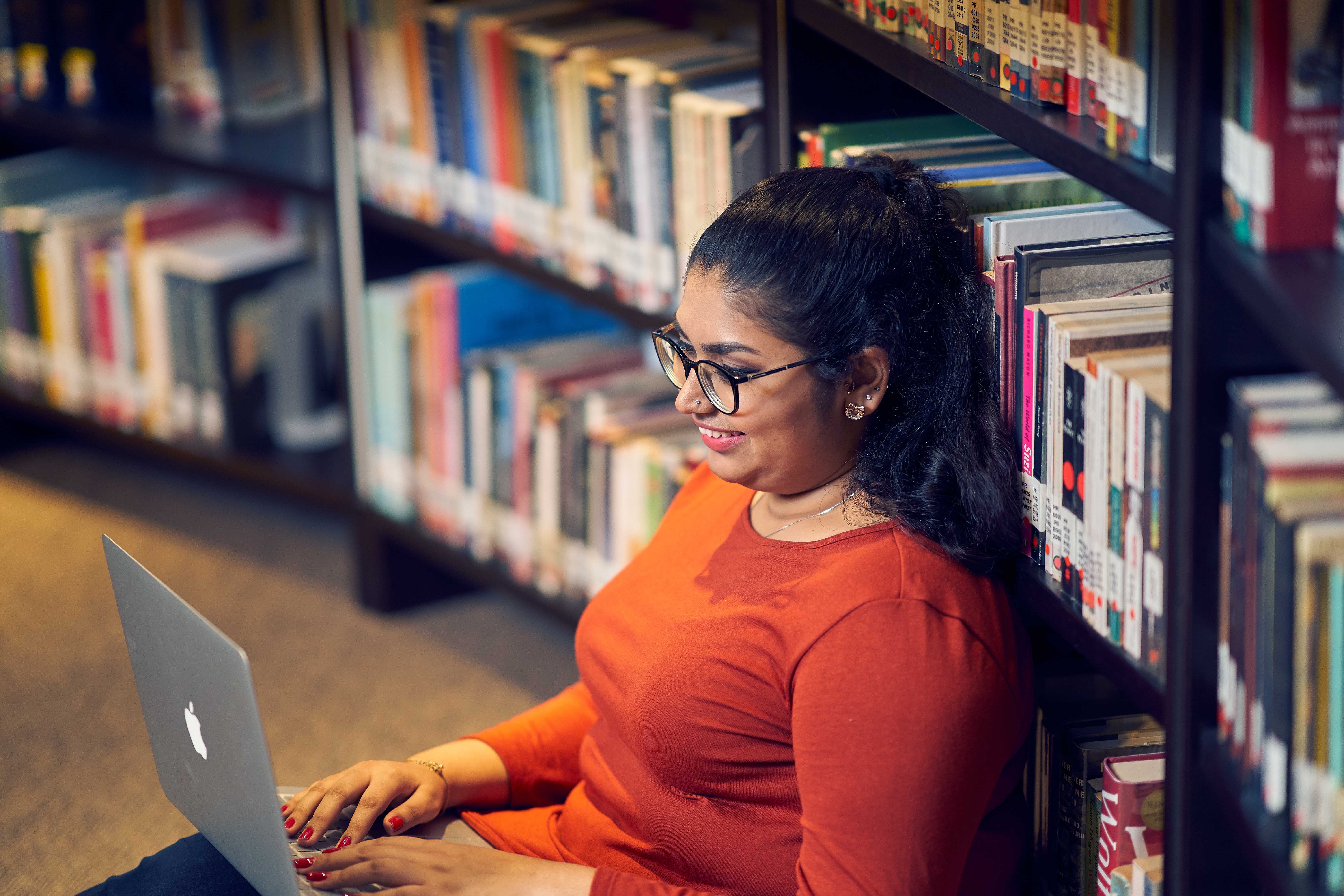 student using laptop in library