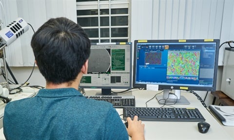 Researcher studying microstructure of 3D printed stainless steel