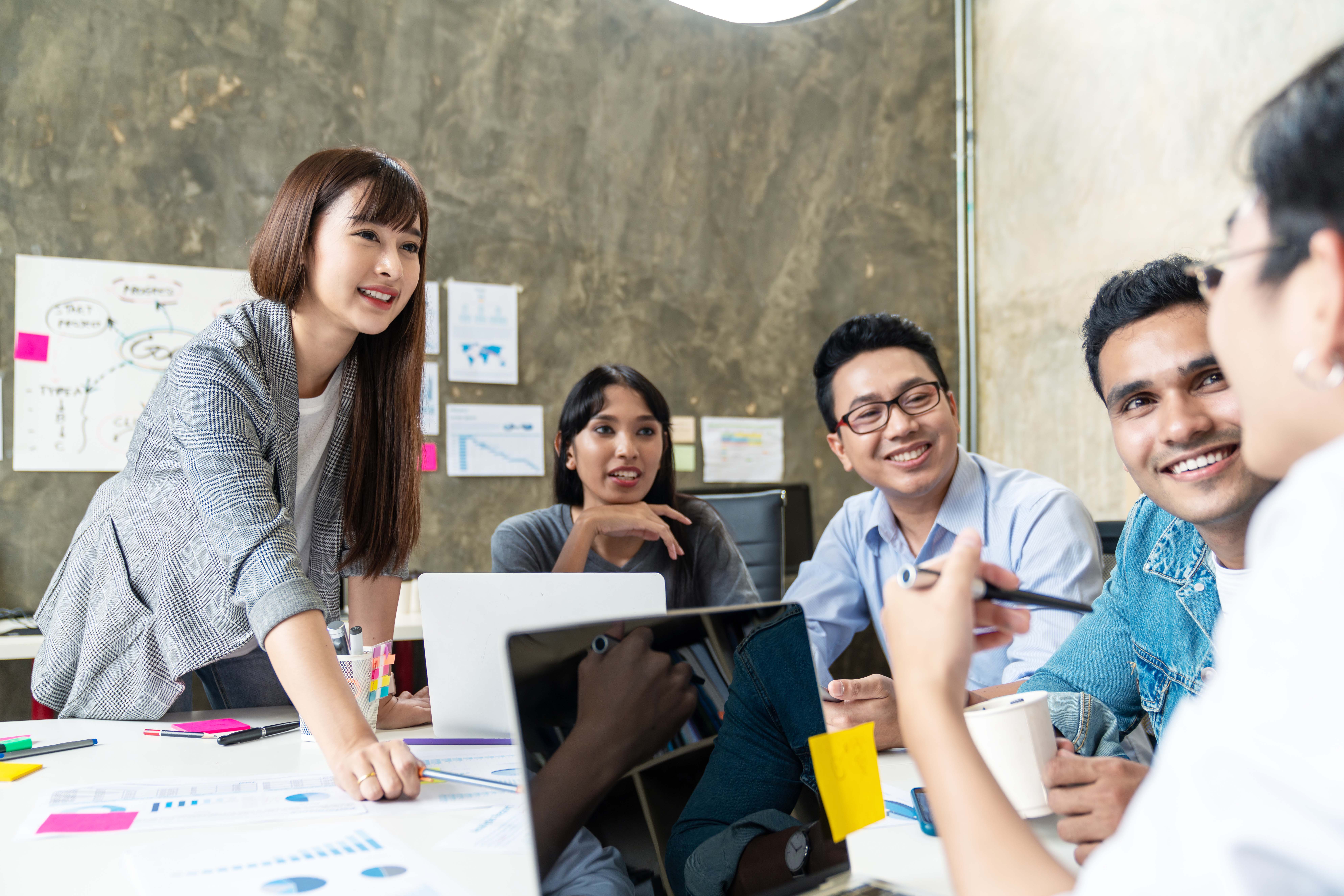 Working adults smiling in a project discussion meeting