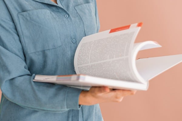 person flipping through a science journal or book