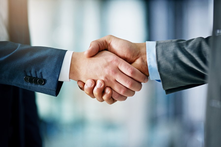 An NBS professor shaking hands with an industry partner