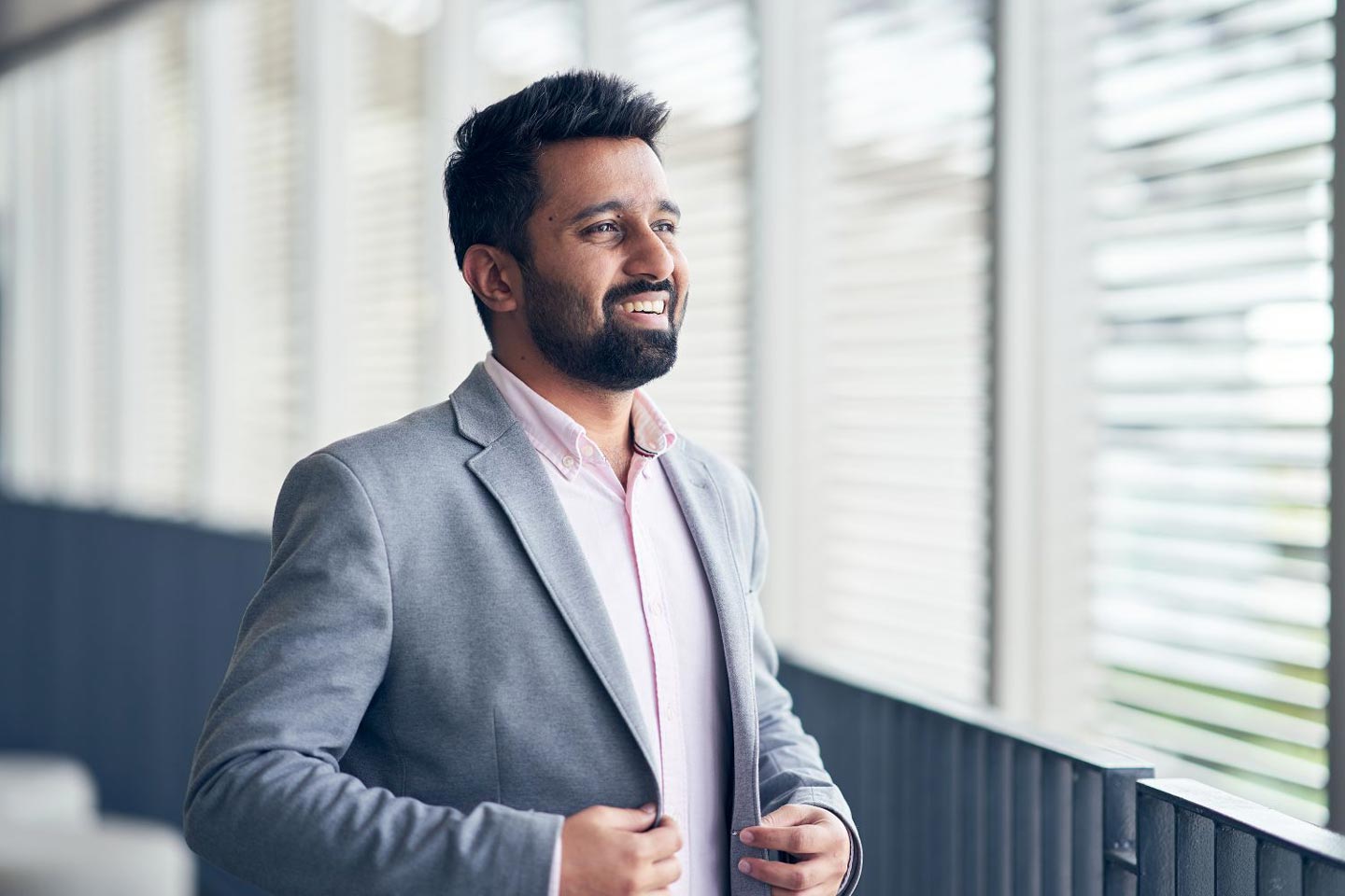Nanyang Professional MBA student smiling, buttoning up his suit jacket