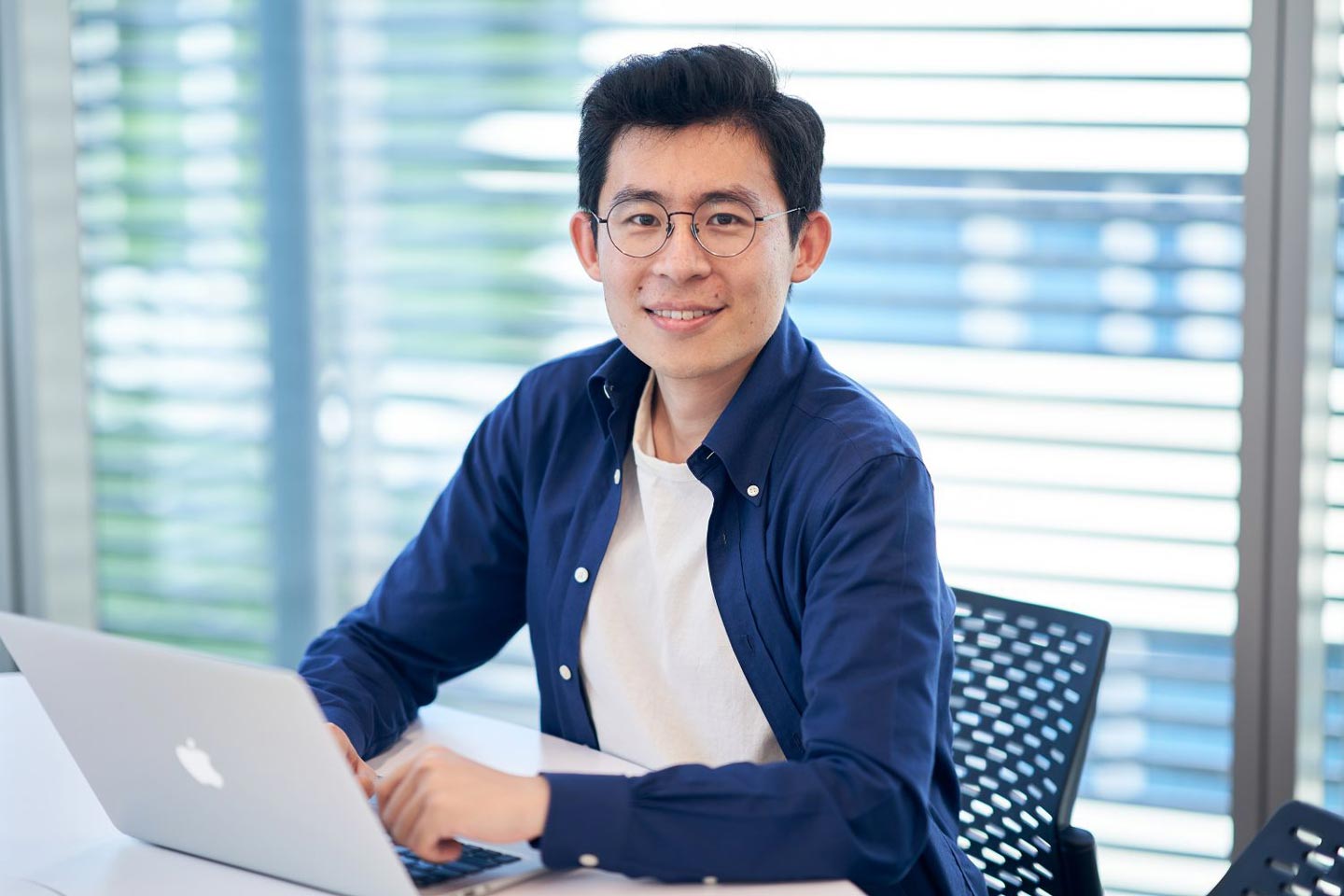 Man at laptop smiling at camera