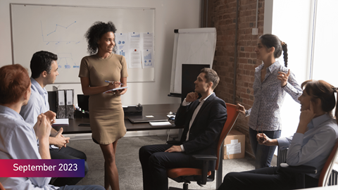 Employees discussing at workplace, with the text September 2023 on bottom left of image