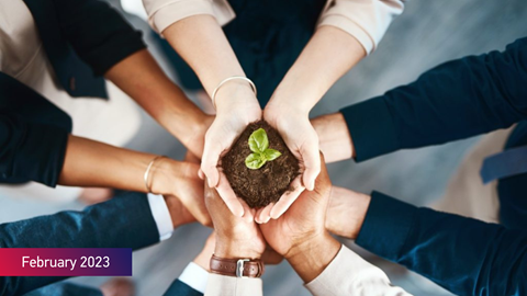 February 2023 in text over the image of hands carrying a plant rooted in soil