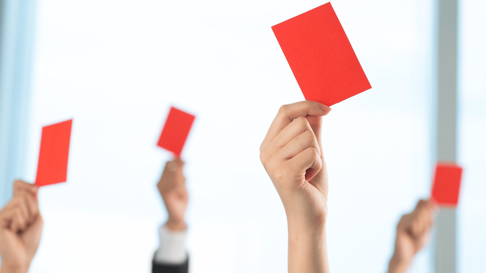 A group of people declined something showing red card on the foreground