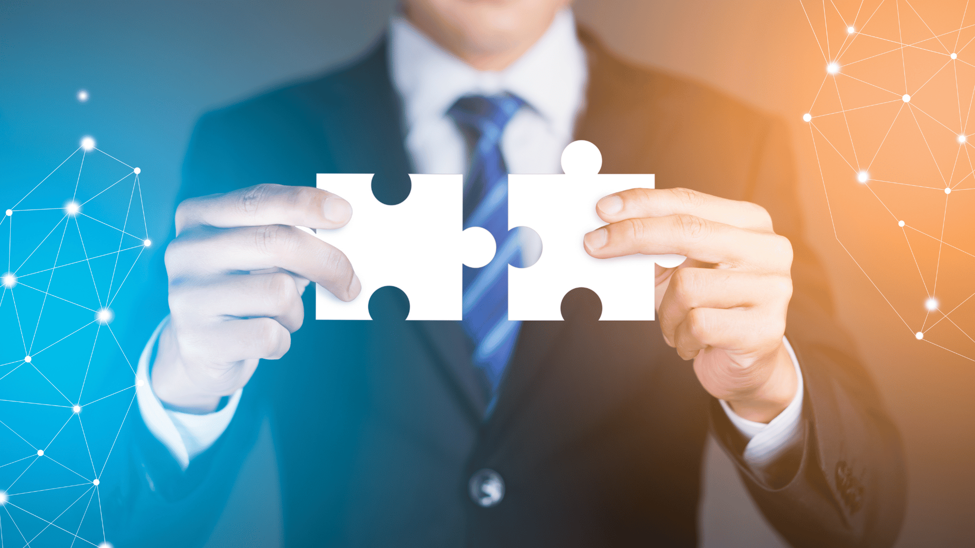 Businessman hands connecting puzzle pieces representing the merging of two companies
