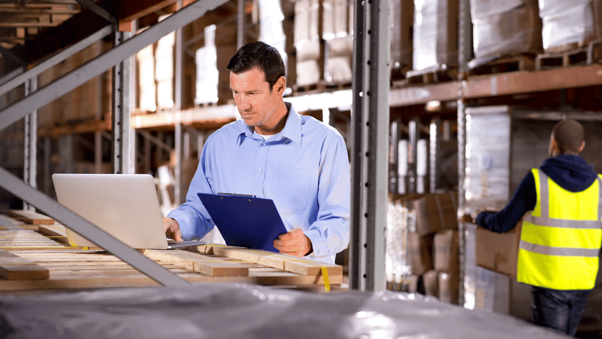 Manager using laptop in a warehouse