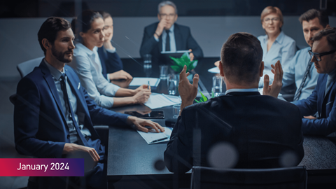 Executive director talks to a Board of Directors and Business Associates in a conference room January 2024 in text