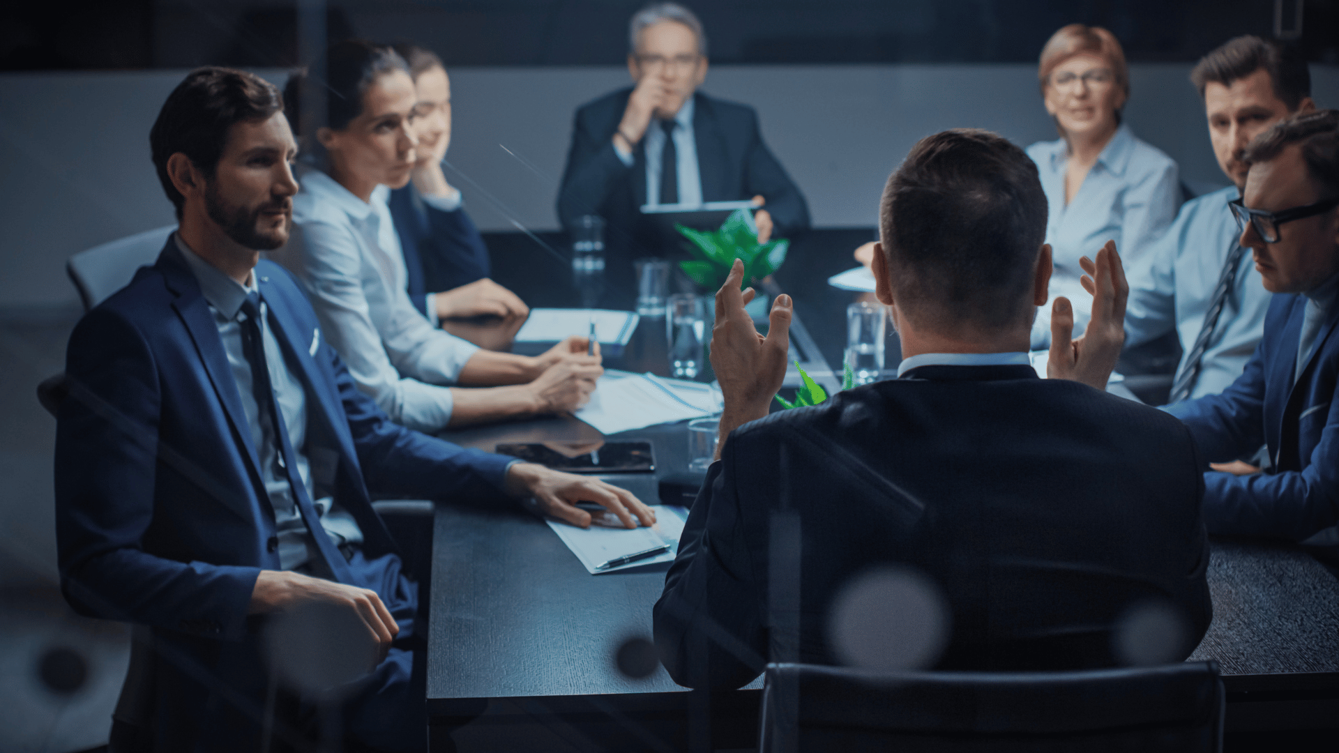 Executive director talks to a Board of Directors and Business Associates in a conference room