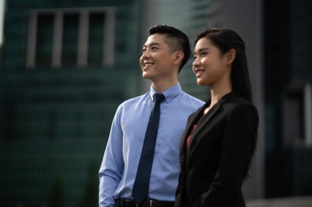 Two young professional executives at Nanyang Business School looking in the same direction