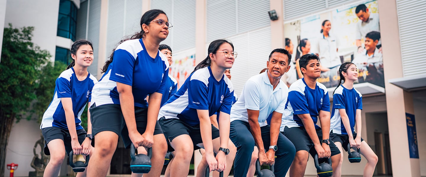 Kettlebell Workout with Secondary School Students And PE Teacher In Outdoor Workout