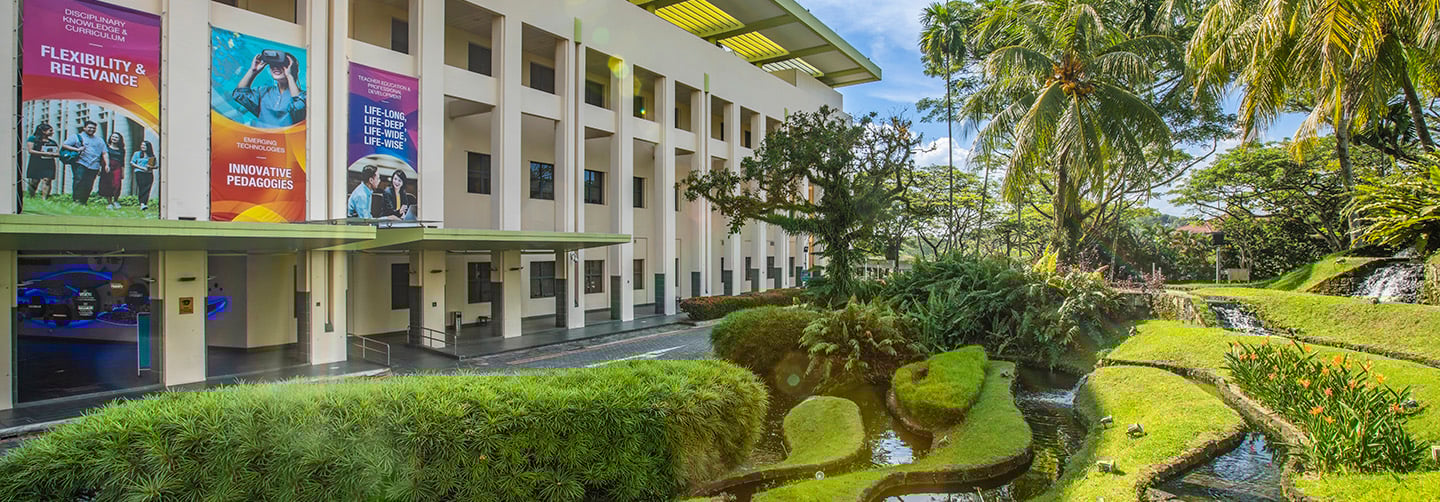 Lush Green Landscaping on NIE Campus Driveway Entrance with Building Banners