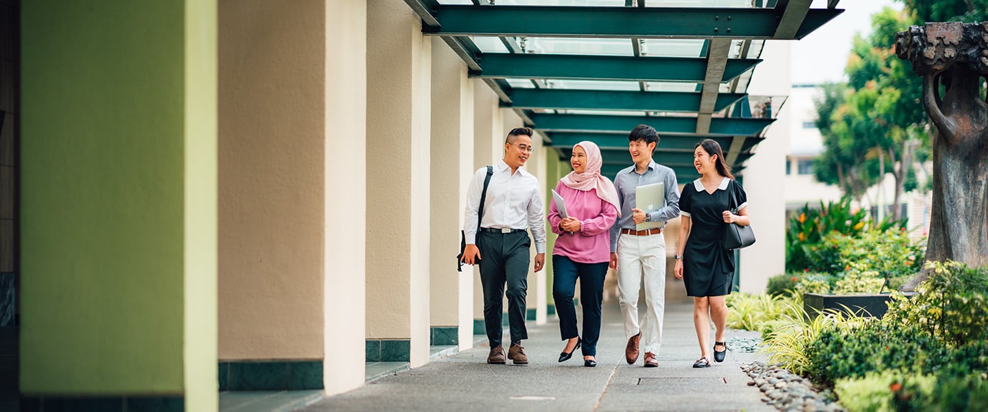 Malay Girl in Pink with Group of 4 Young Adults Walking in NIE Campus Corridor Next to Trees