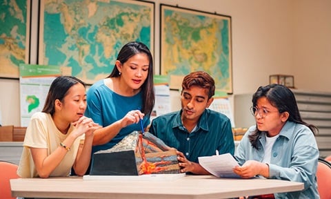 A Volcano Model Discussed by Group of 4 young students in casual business wear (720x432px)