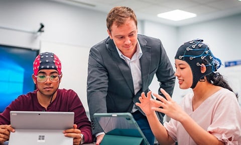 EEG Brain Caps 2 Students And A Caucasian Teacher In Grey Suit (720x432px)