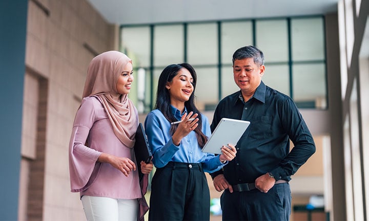 iPad Lecture Theatre 1 Lady in Blue Top and Malay Girl Wearing Pink Tudung with Senior Male Teacher Wide (720x432px)