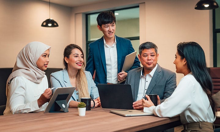 iPad Older Male Teacher in Grey Blazer iPad Lady Teacher Blue Blazer with 3 young students in business wear (720x432px)