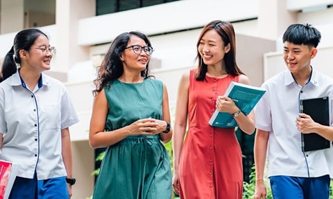 Walking Tanned Female Teacher in Green Dress and Chinese Girl in Red Dress Walking with 2 Secondary School Students Closeup (720x432px)