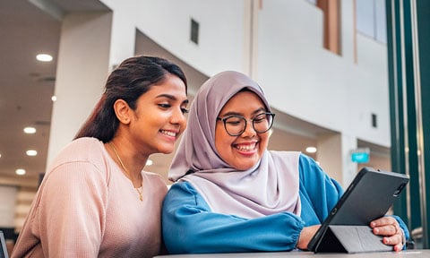 iPad Malay Student Wearing Tudung with Indian Girl in Pink Top Looking at iPad in NIE Library (480x288px)