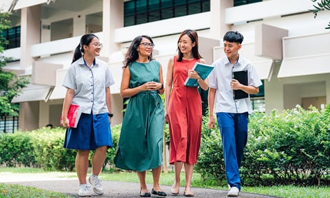 Walking Tanned Female Teacher in Green Dress and Chinese Teacher in Red Dress Walking with 2 Secondary School Students with Books (480x288px)